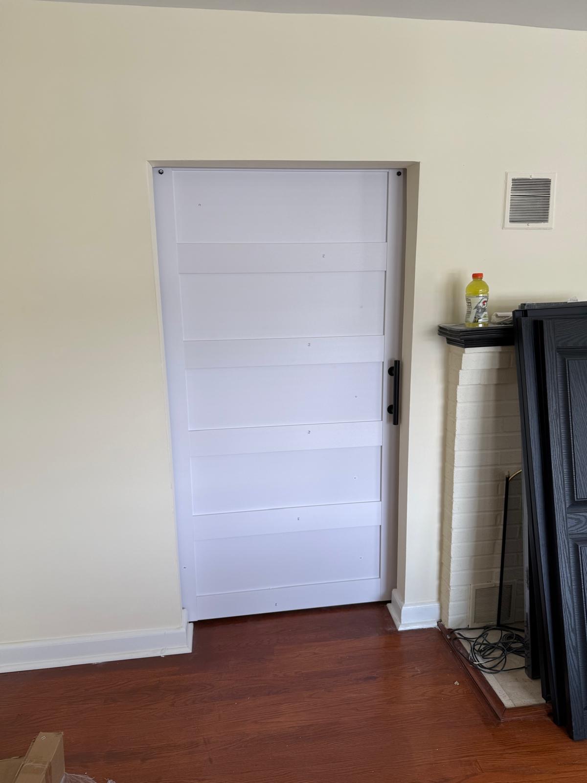 White barn door beside a fireplace