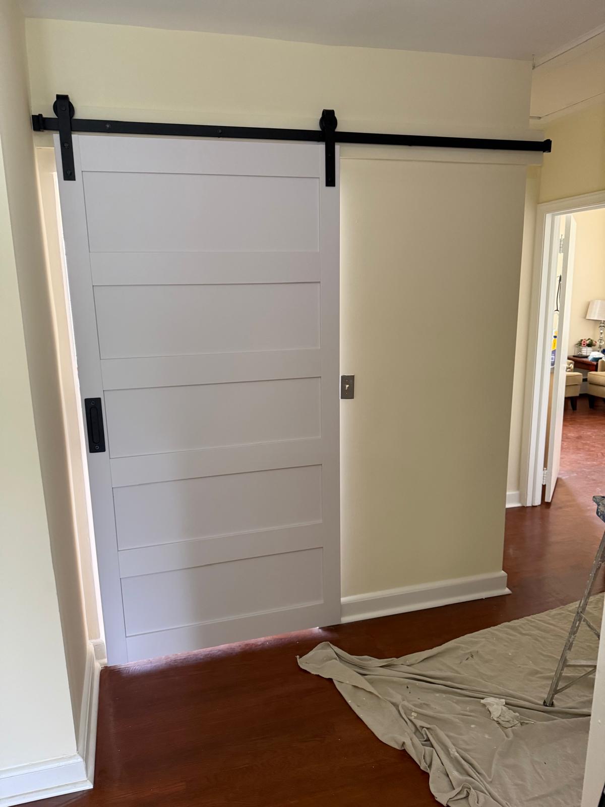 Finished white barn door in a hallway