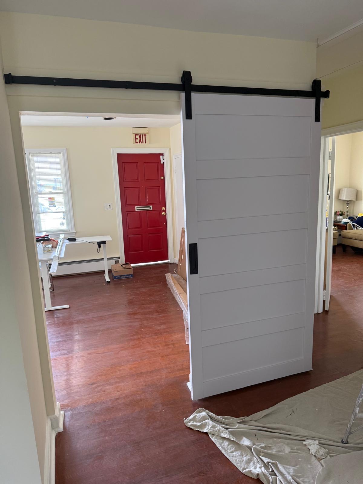 White sliding barn door with black hardware installed by EDmans Construction