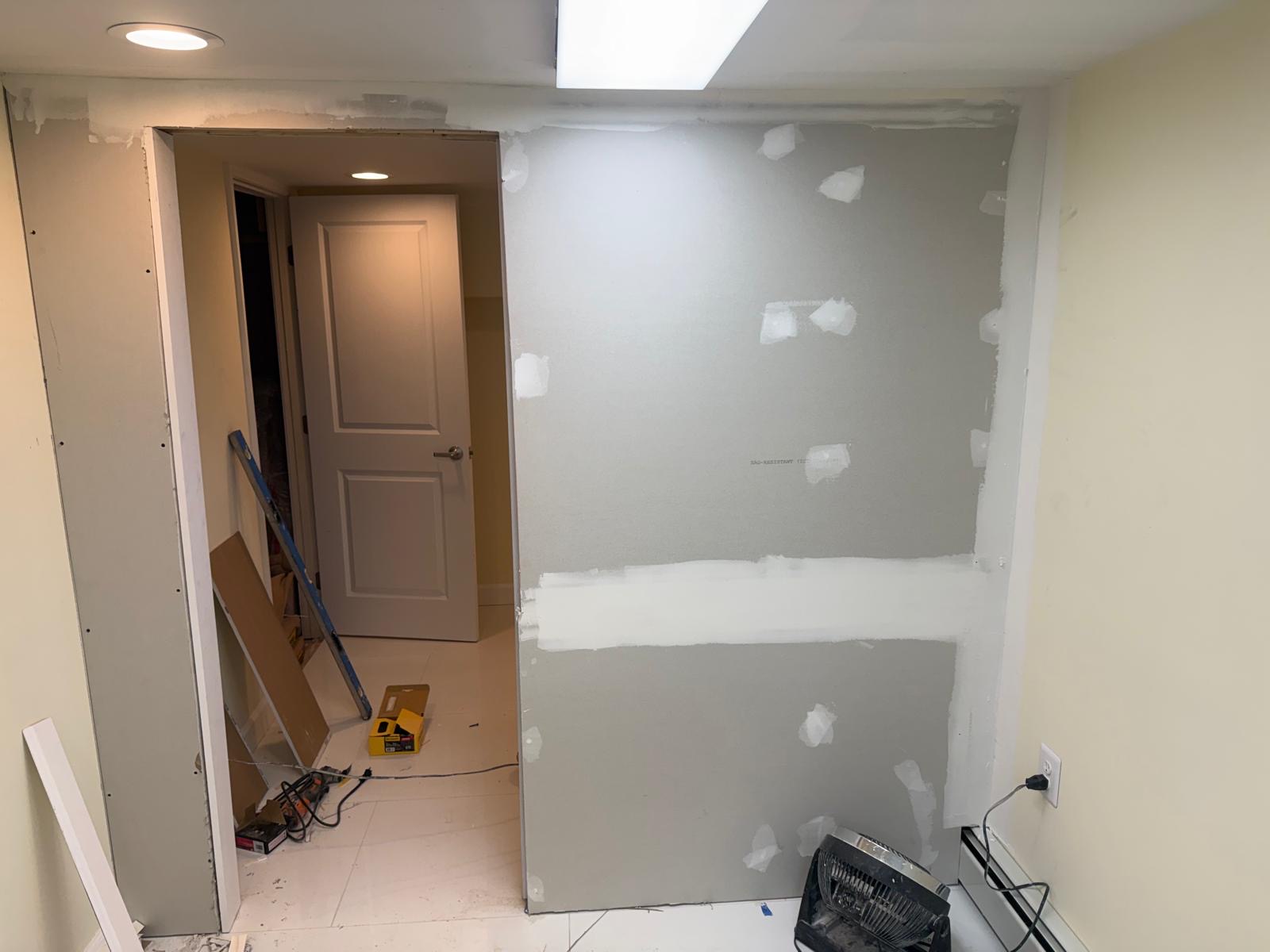 Fresh drywall being taped and mudded